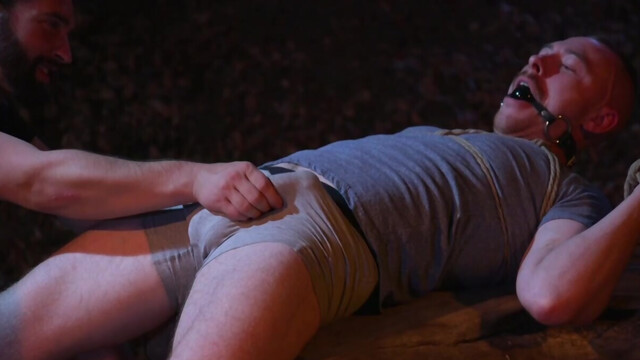 Nude male slave shared in rough kinks by two dominant hunks