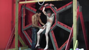 Pouring wax on the body of the tied, tattooed fella