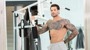 Handsome man with tattoos working out with a hunk