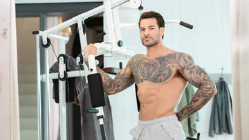 Handsome man with tattoos working out with a hunk