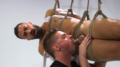 Adam Ramzi is tied up and hanging in the air while getting a BJ