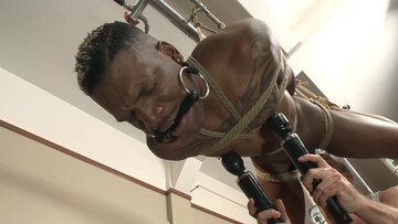Muscular man roughly treats his ebony male slave with toys in the ass